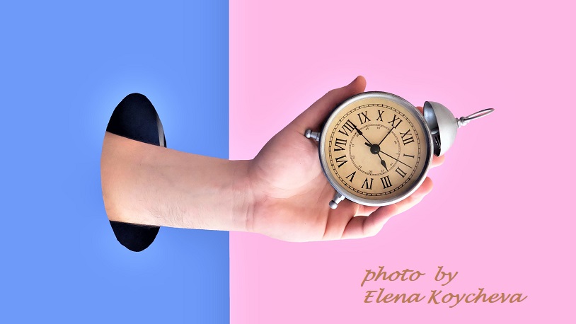 Elena Koychevaの作品 青い壁の丸い穴から時計を持った手が出ている
