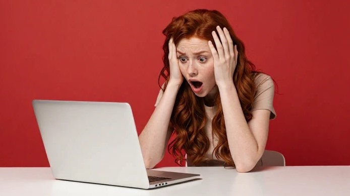 パソコンを見て驚いている女性